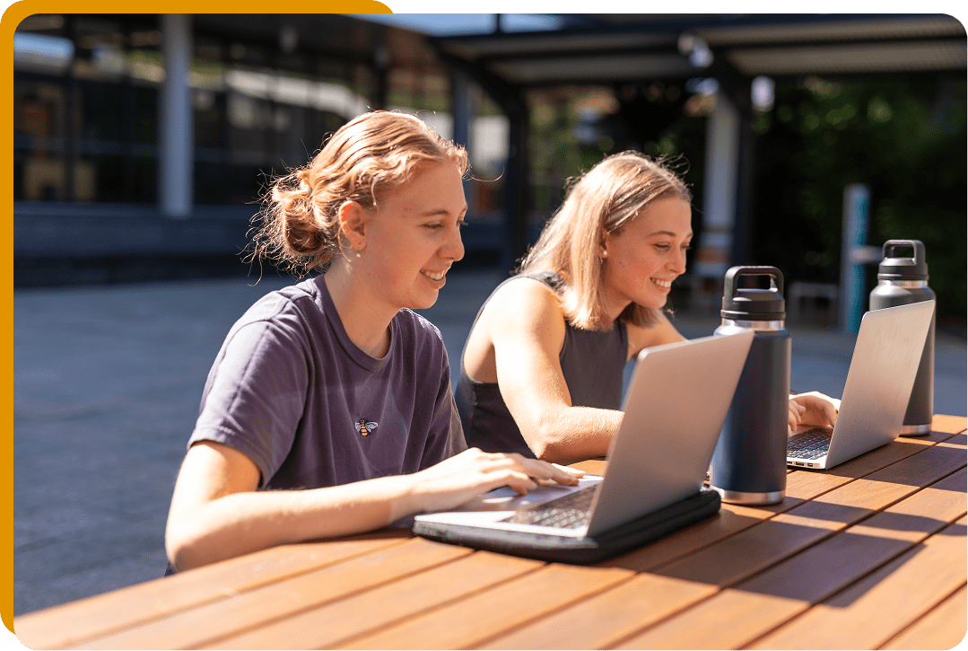 Friends working on laptops outside