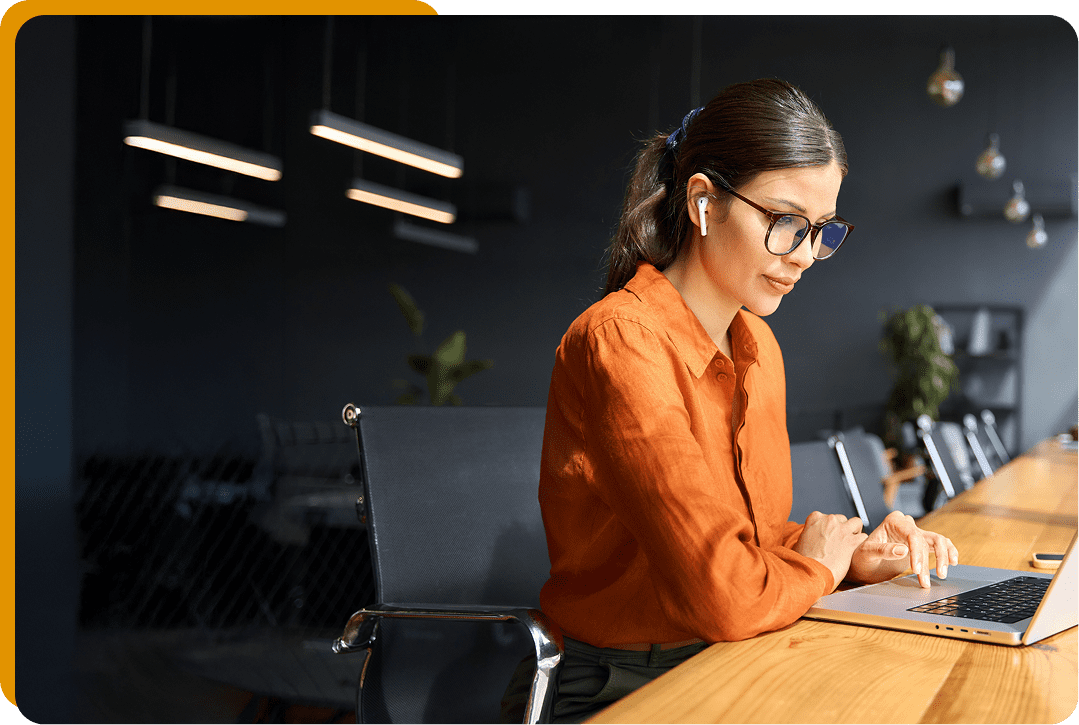 Woman working on laptop with earphones