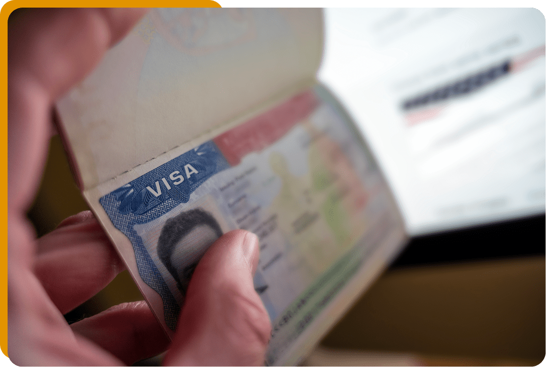 Hand holding an open passport with visa