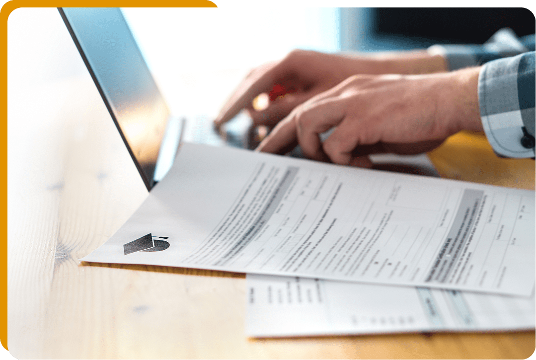 Papers clipped on a desk near laptop